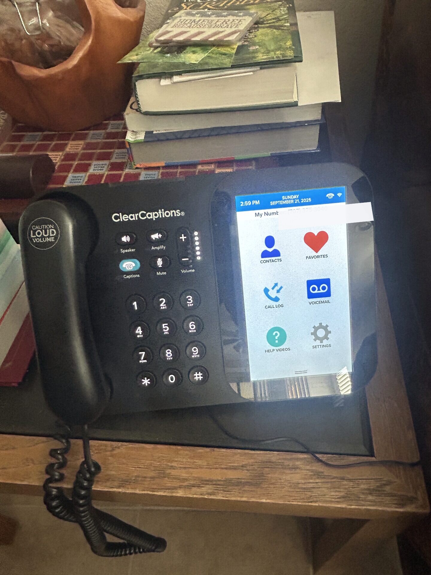 Real ClearCaptions phone with the private phone number redacted on the display
