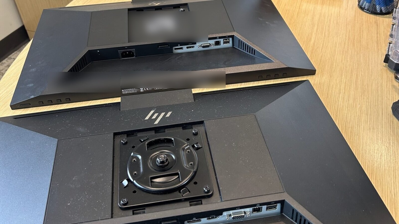 Real project photo showing monitor backs port panels and mounting hardware detail with label areas blurred