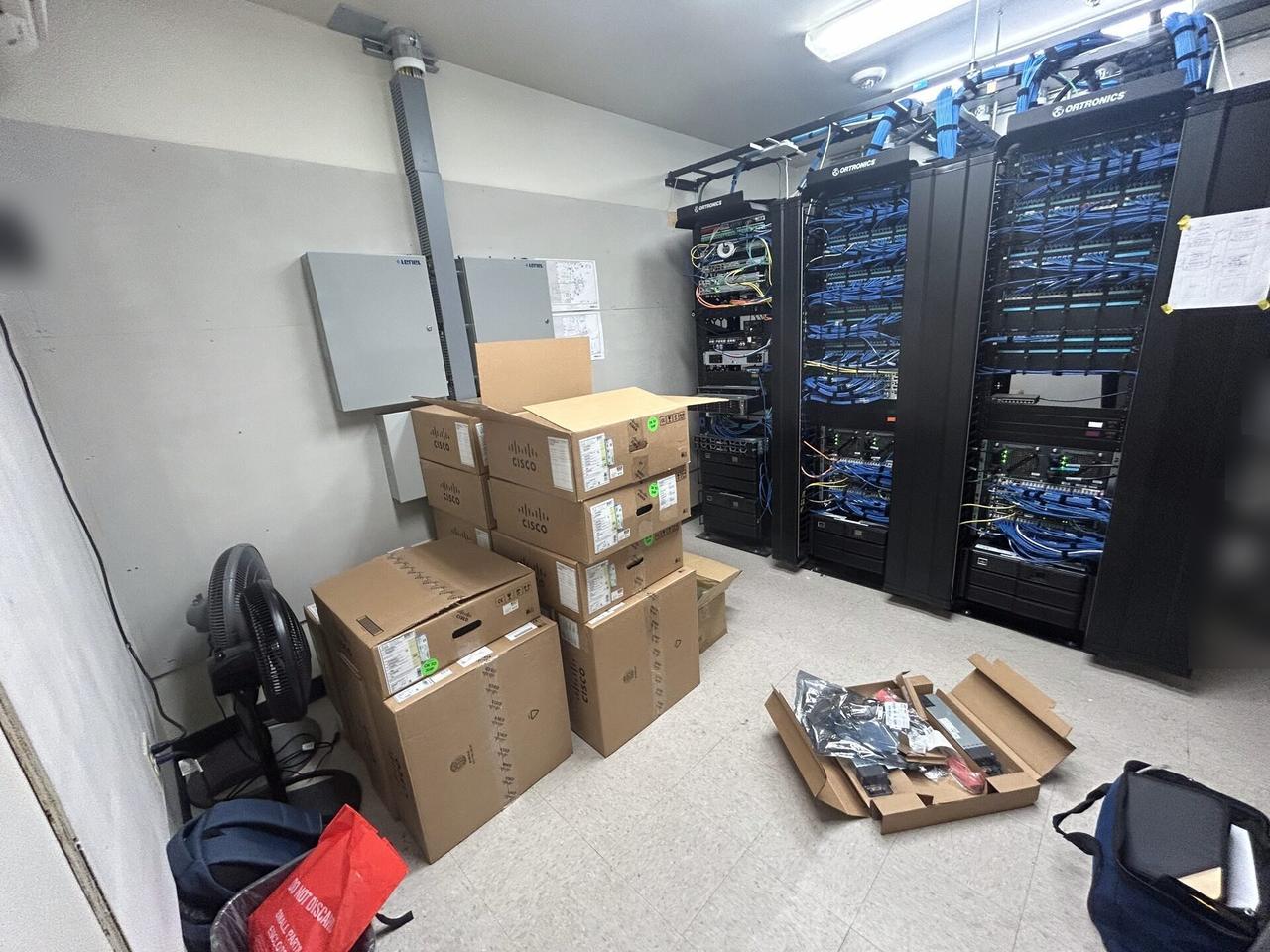 Onsite service photo showing server-room cabinet and structured network equipment at the server-room handoff point