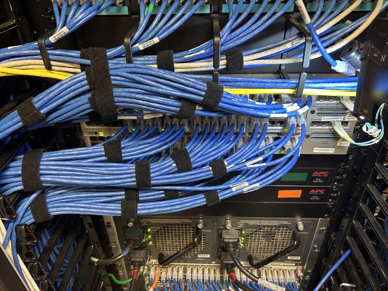 Rack-mounted network hardware during service with structured cabling visible documented for a smart technology service call