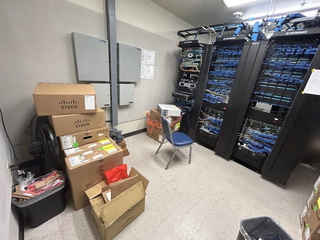 Public-safe portfolio image of server-room cabinet and structured network equipment with rack cabling organized