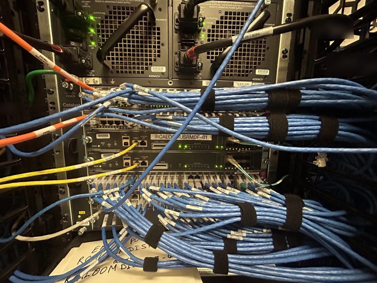 Alrty field photo with network rack and patch panel cabling during network hardware support