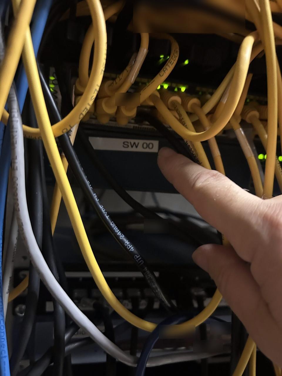 Onsite service photo showing rack-mounted network hardware during service with private labels omitted