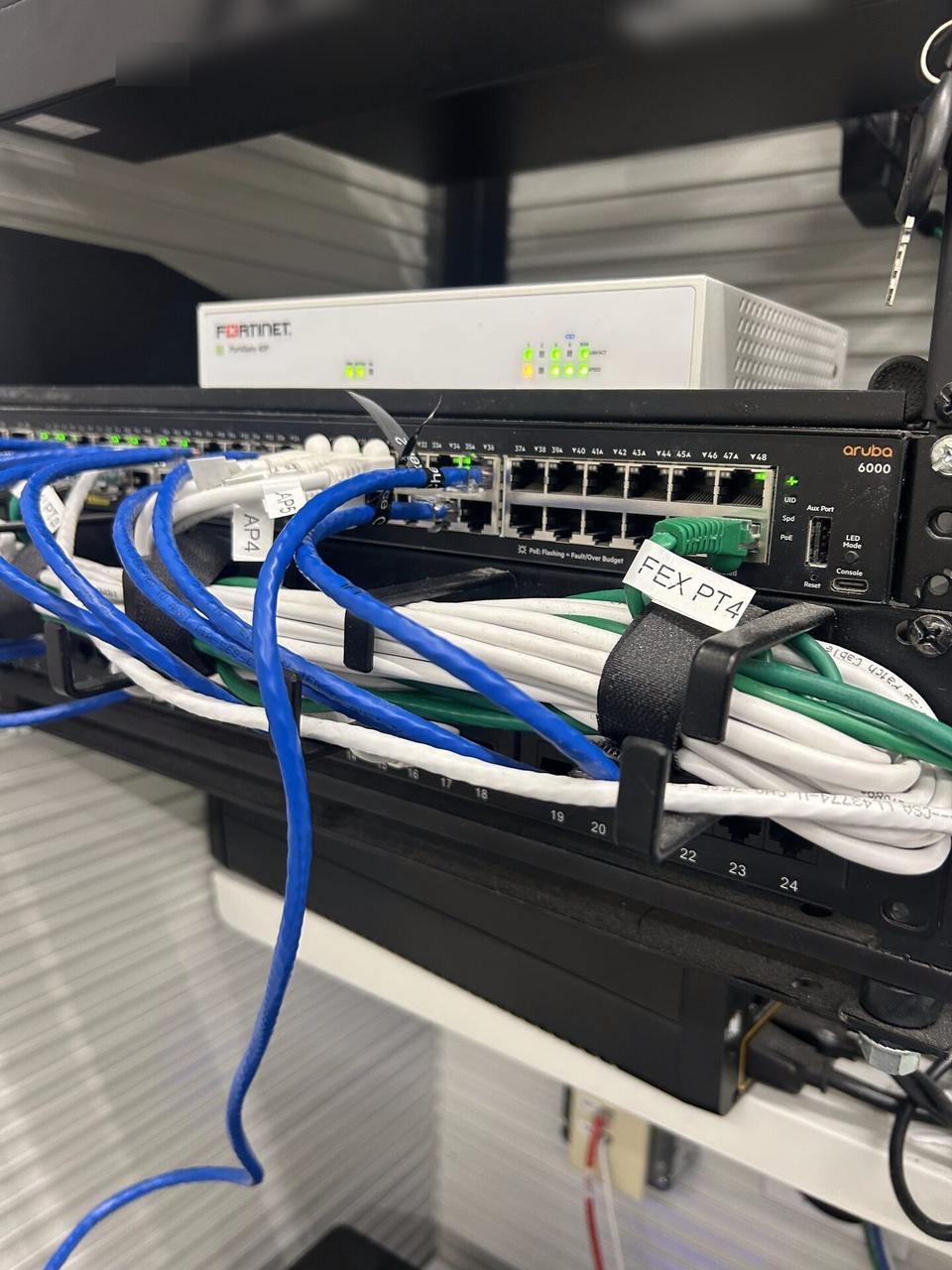 Real low-voltage equipment shelf with patch panel ports and routed Ethernet cables