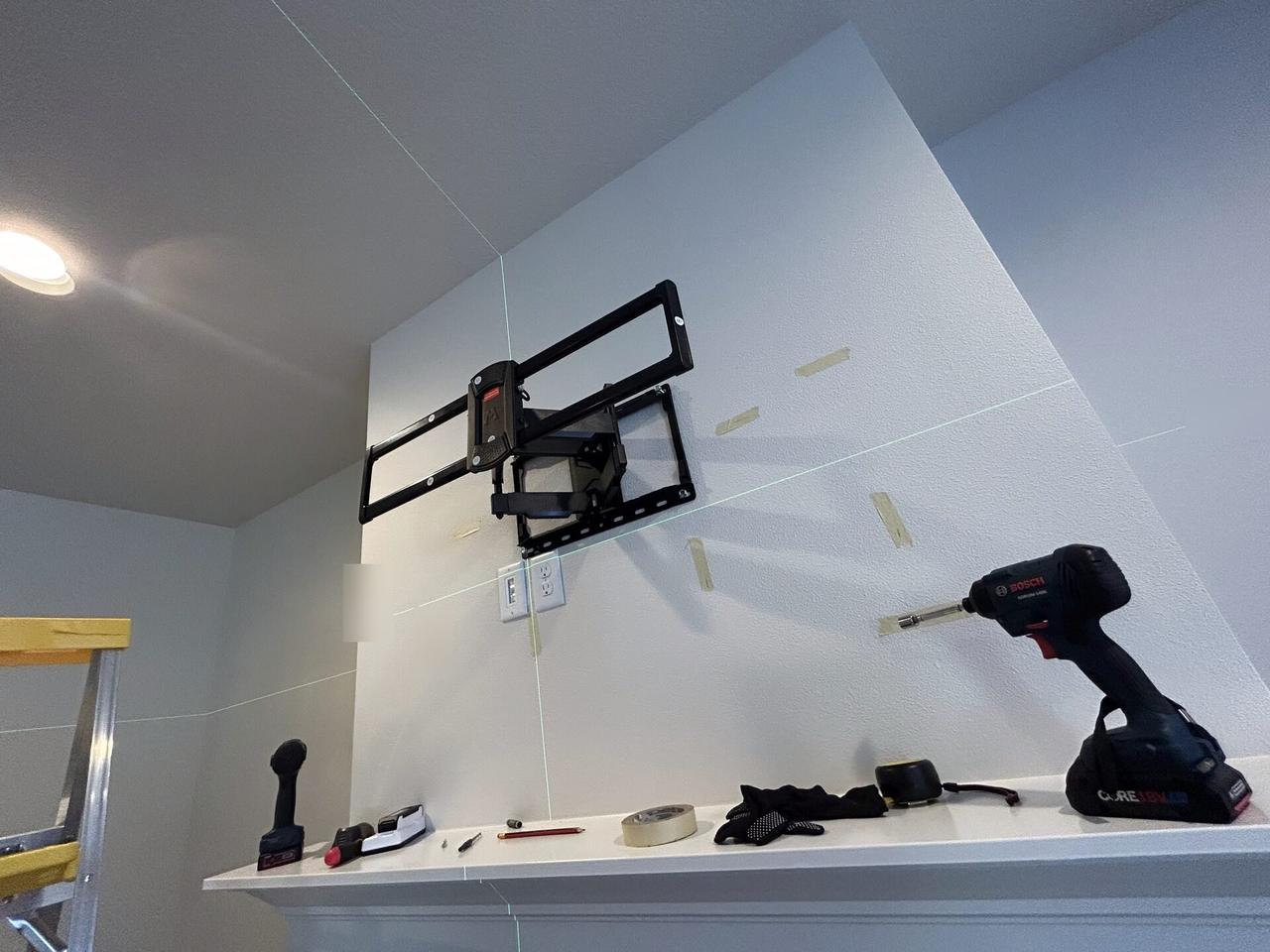 Onsite service photo showing wall-mounted TV setup and cable routing with private room details omitted