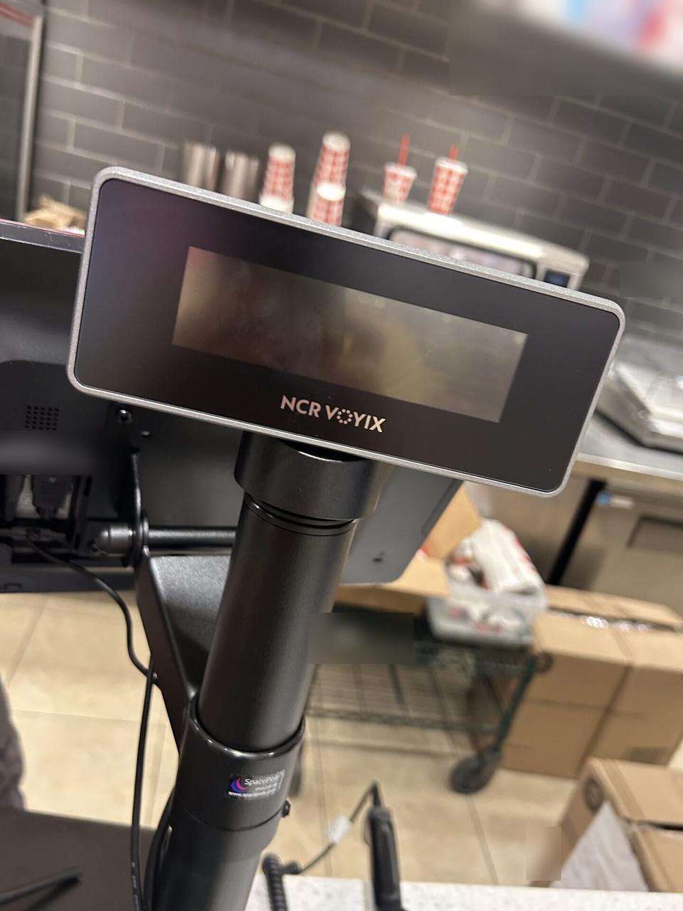 Onsite service photo showing checkout station POS hardware with private labels omitted