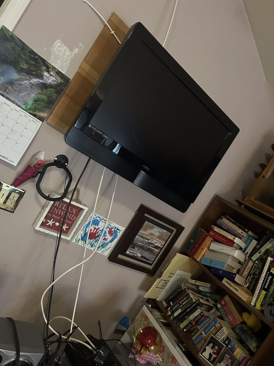 Public-safe portfolio image of wall-mounted TV setup and cable routing during TV service preparation