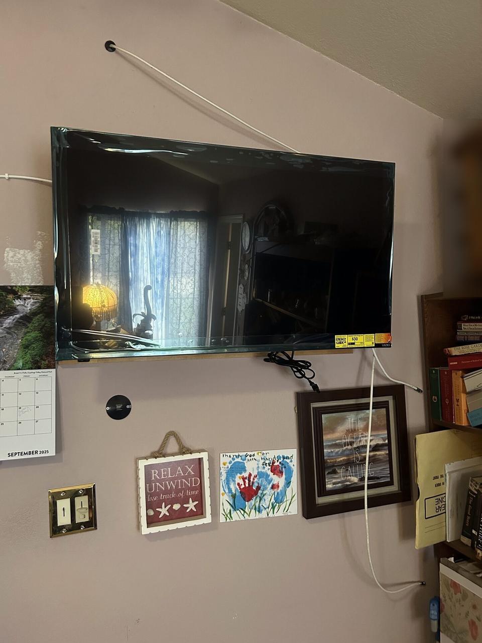 TV mounting or home theater setup detail with display placement, mount work, cabling or finished installation context