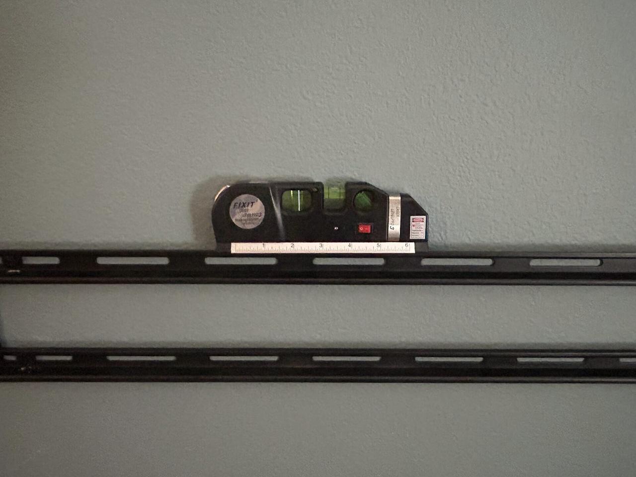 TV mounting or home theater setup detail with display placement, mount work, cabling or finished installation context