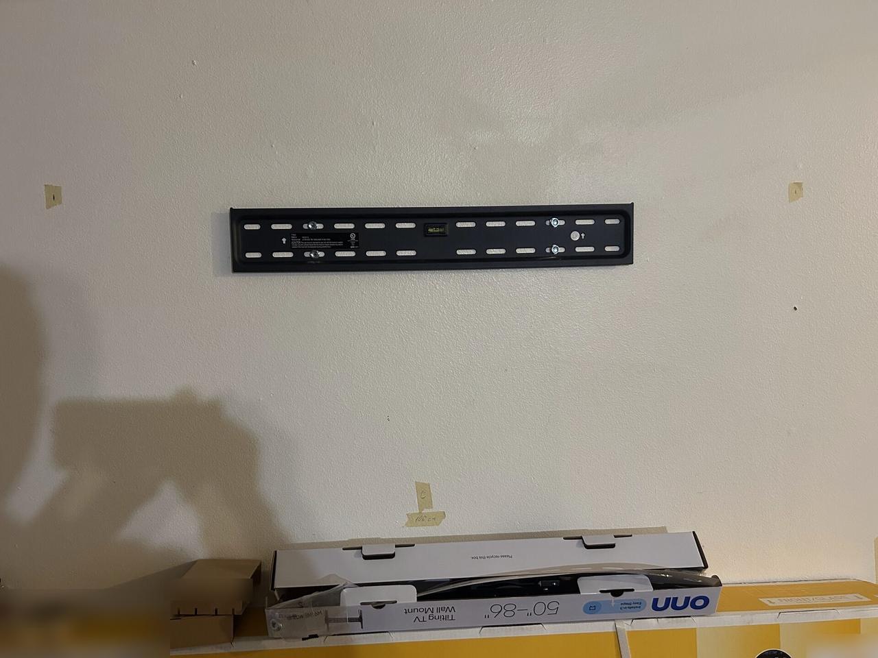 TV mounting or home theater setup detail with display placement, mount work, cabling or finished installation context