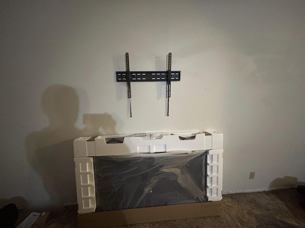 TV mounting or home theater setup detail with display placement, mount work, cabling or finished installation context