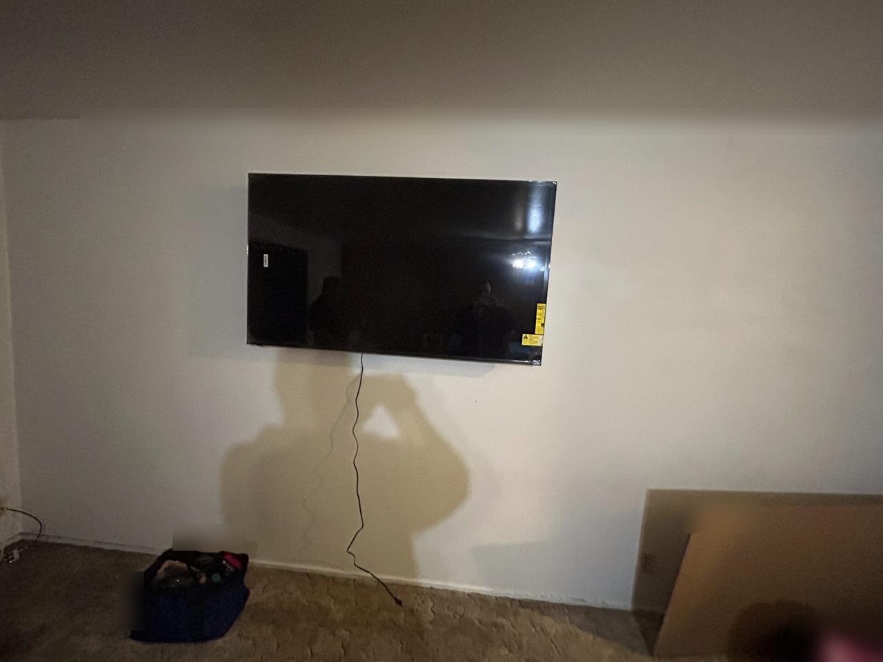 TV mounting or home theater setup detail with display placement, mount work, cabling or finished installation context