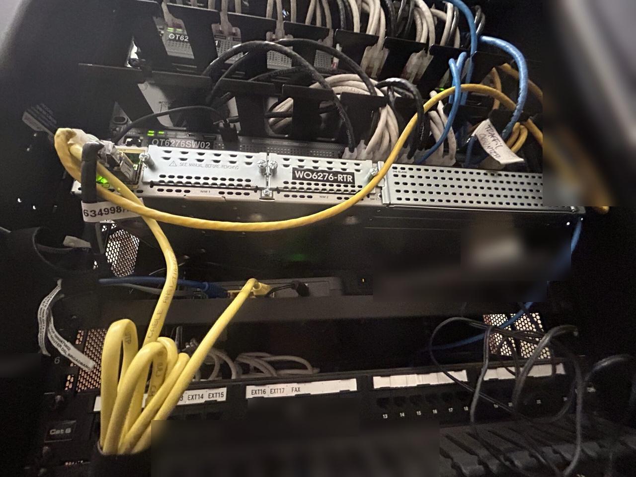 Network rack and patch panel cabling with private labels omitted documented for a smart technology service call