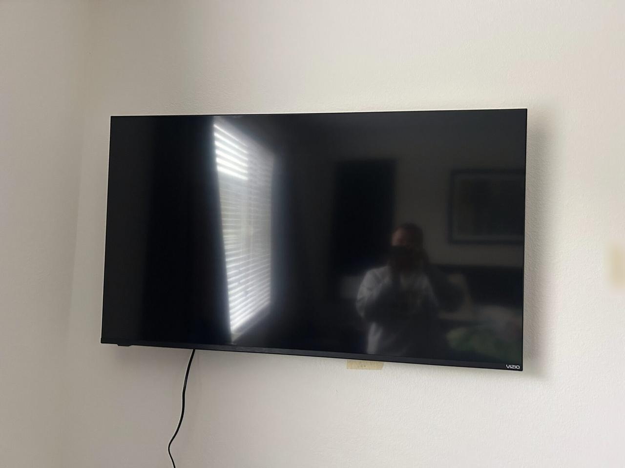 TV mounting or home theater setup detail with display placement, mount work, cabling or finished installation context