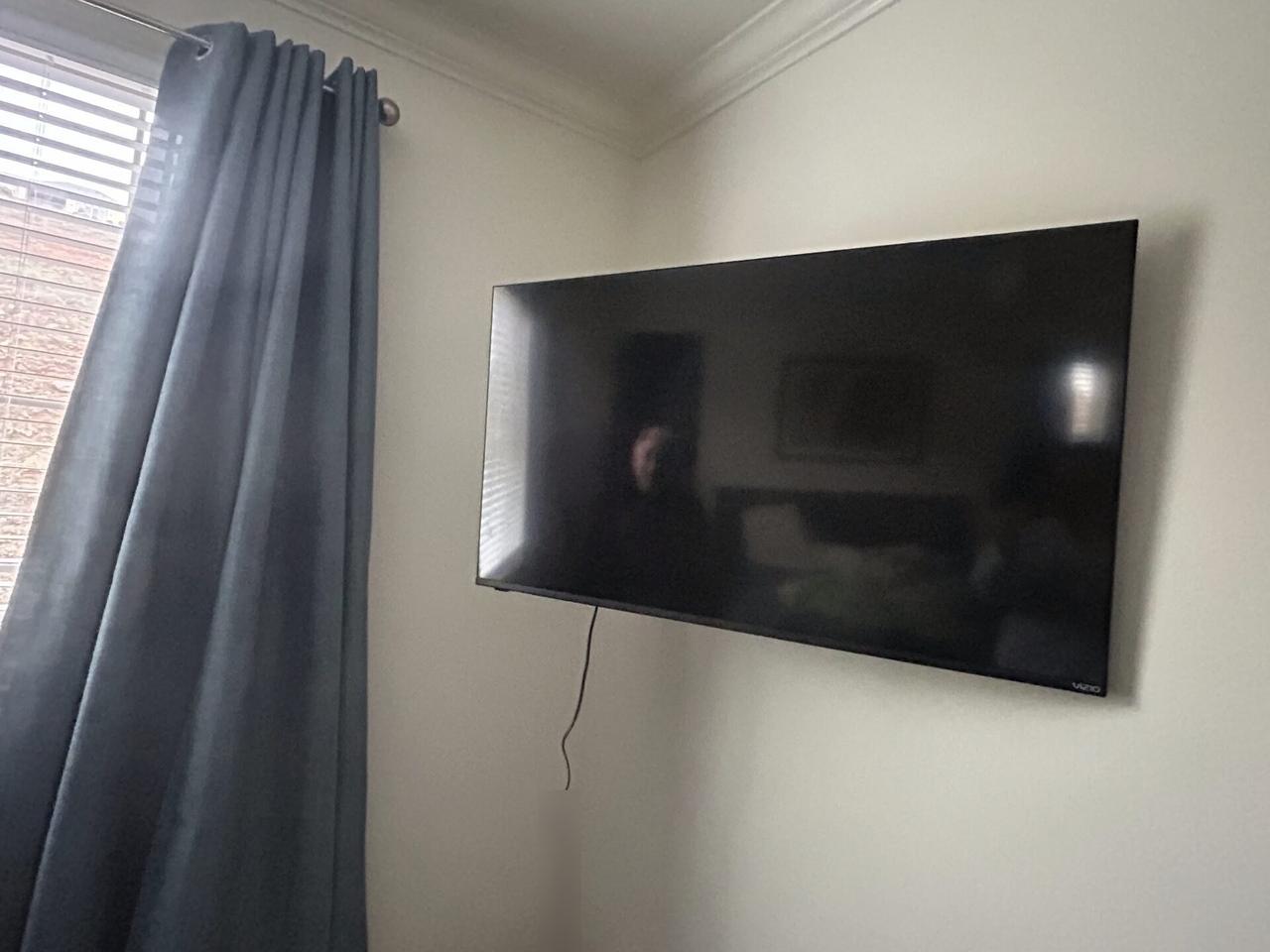 TV mounting or home theater setup detail with display placement, mount work, cabling or finished installation context