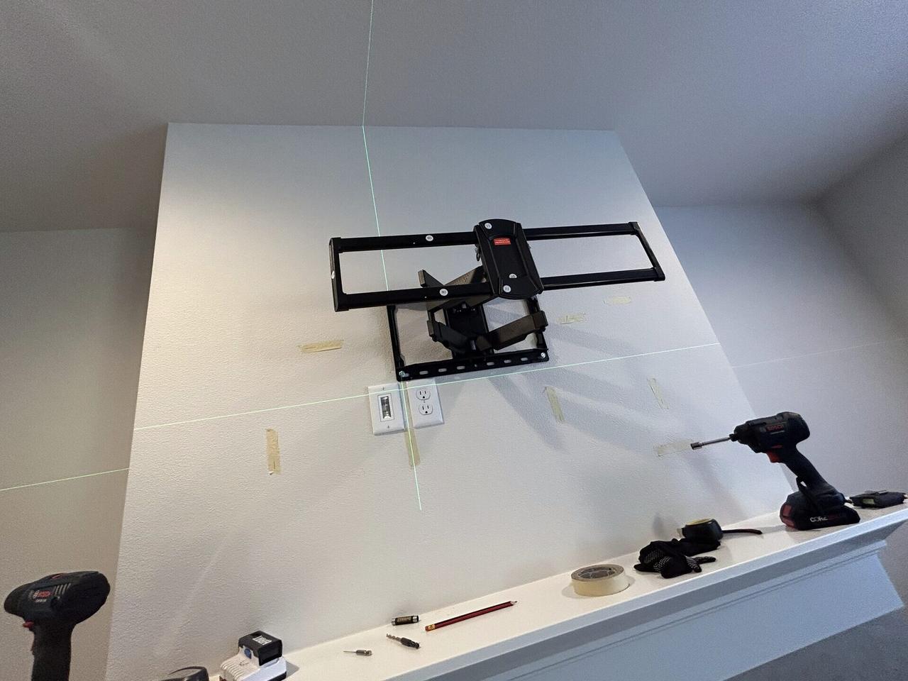 TV mounting or home theater setup detail with display placement, mount work, cabling or finished installation context